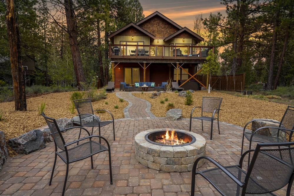 The Beaver Cabin at dusk, fire pit lit, deck overlooking the trees