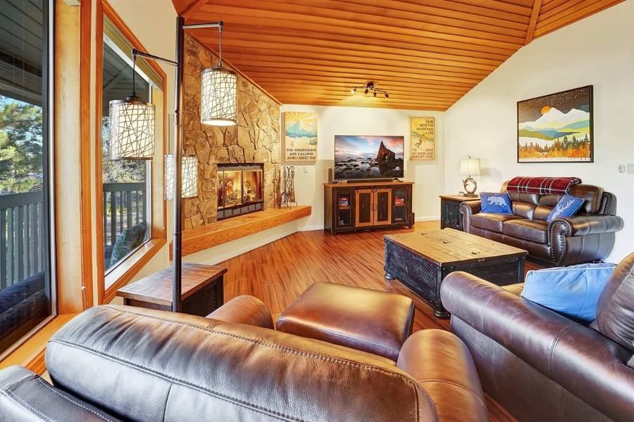 Rogue Cabin living room with stone fireplace and wood ceiling